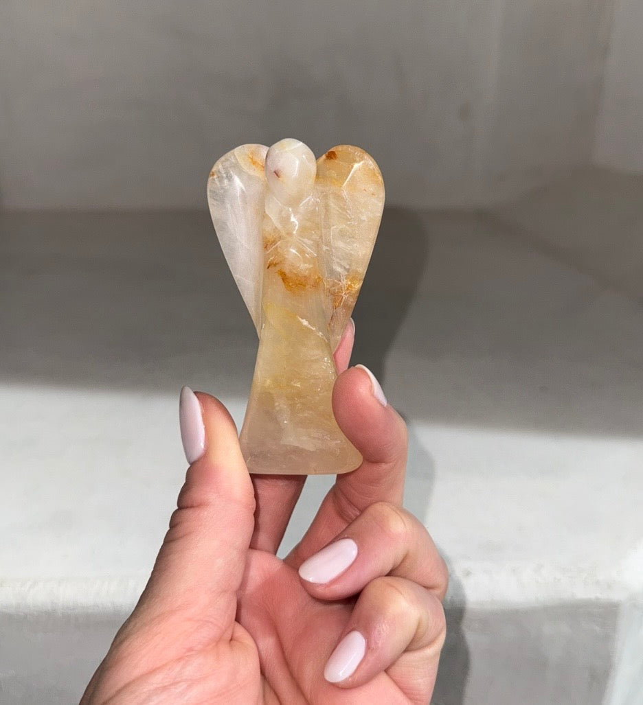 Hand holding Guardian of Healing Golden Healer Quartz crystal angel — meaningful healing gift and cancer support gift