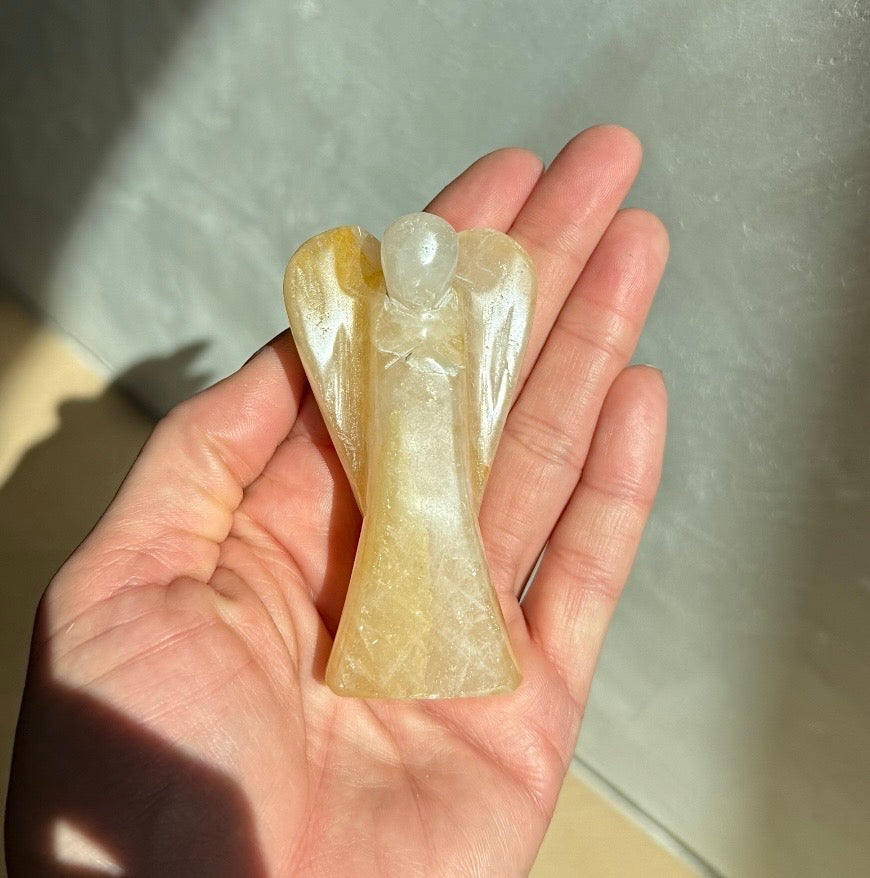 Golden Healer Quartz Guardian Angel held in open hand — artisan crystal healing keepsake supporting Aspen Angels Foundation
