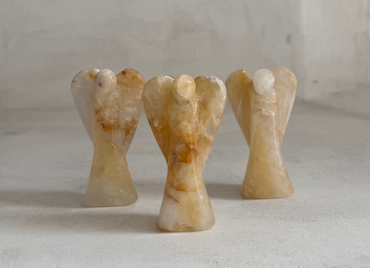 Three Golden Healer Quartz Guardian Angels on white surface — hand-carved crystal healing gifts for sympathy and cancer support
